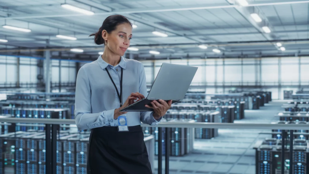 Woman using a laptop in a server room