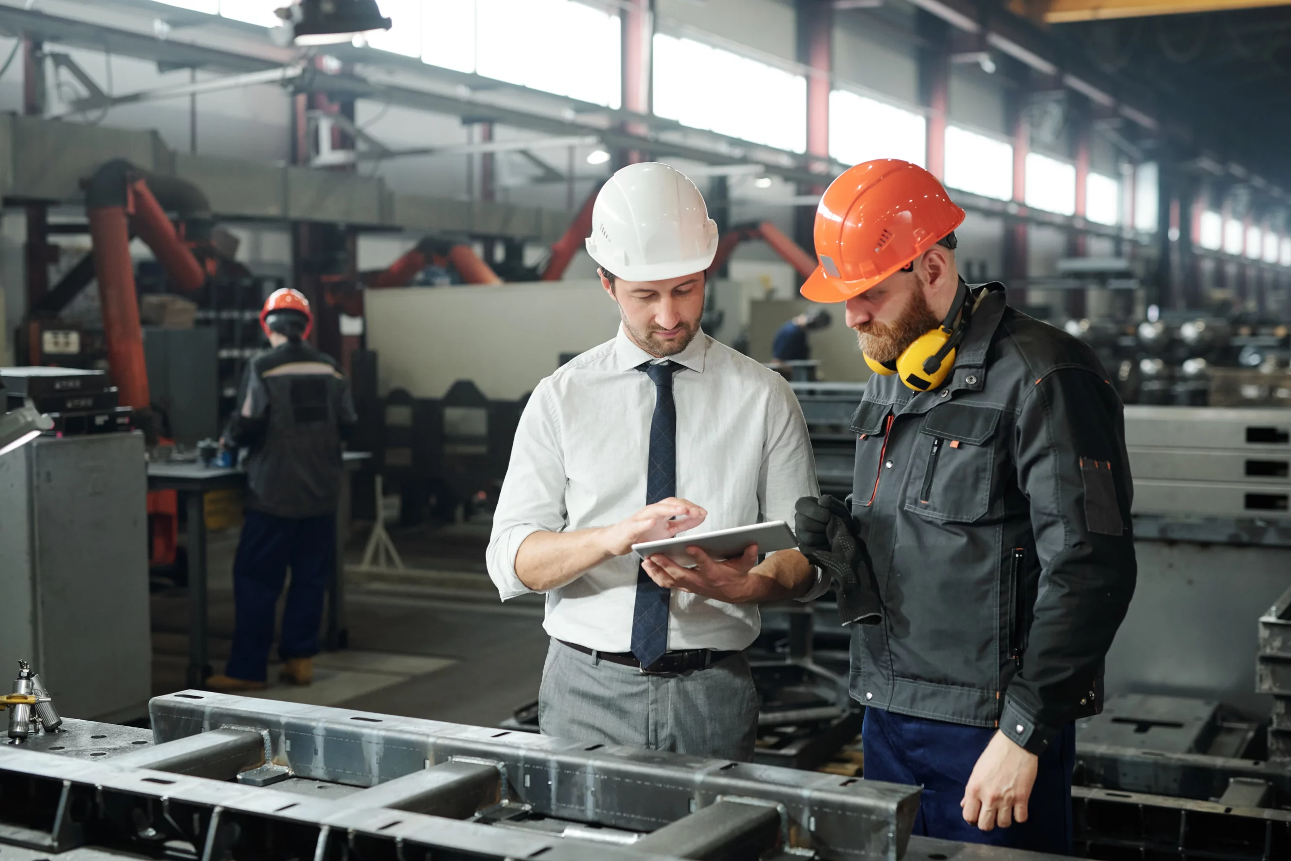 Two men looking at a tablet in a factory