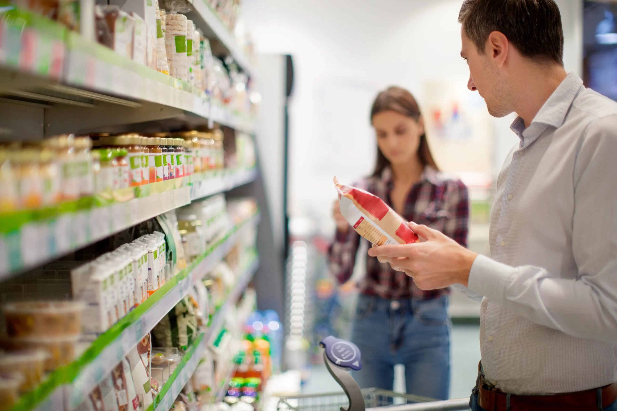Man looking at packet in supermarket