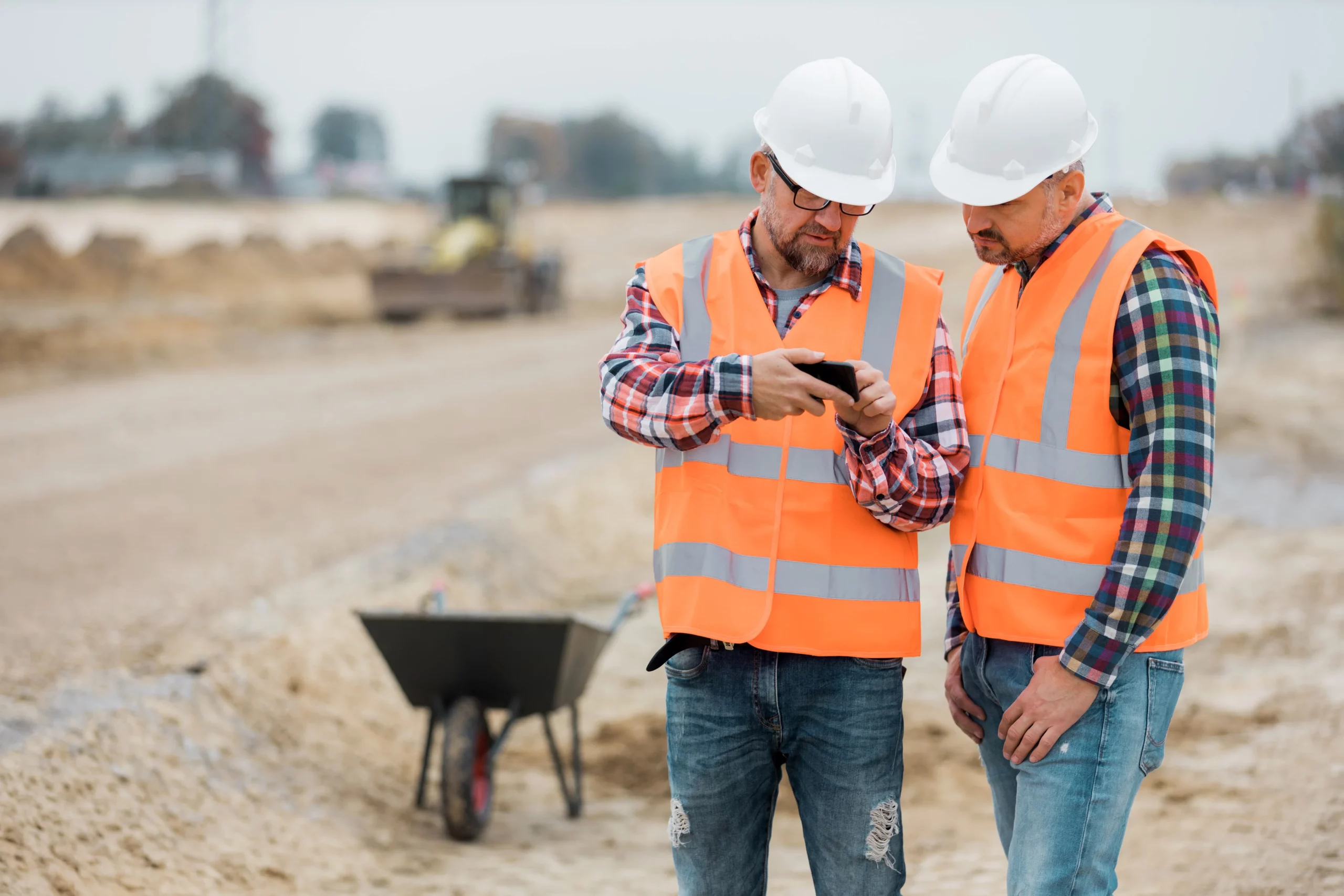 Two construction workers looking on a phone